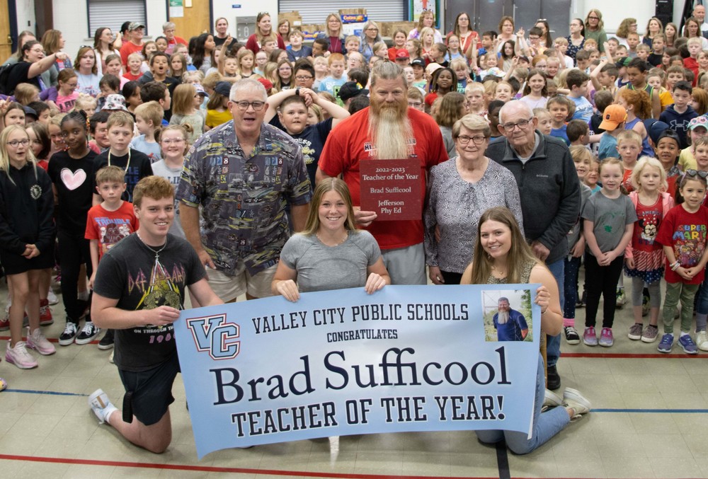 Brad Sufficool's teacher of the year poster photographed with family and students 