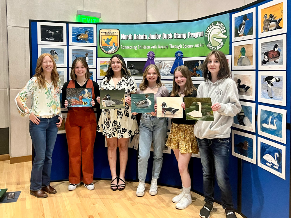 photo of students holding their artwork of ducks